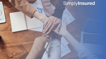 Teamwork - six individuals placing their hands together in camaraderie